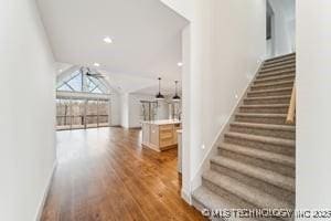 interior space with wood finished floors, recessed lighting, stairway, baseboards, and lofted ceiling