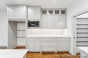 kitchen featuring glass insert cabinets and light countertops