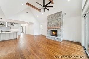 unfurnished living room with wood finished floors, high vaulted ceiling, recessed lighting, a fireplace, and ceiling fan