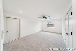 unfurnished bedroom featuring light carpet and a ceiling fan