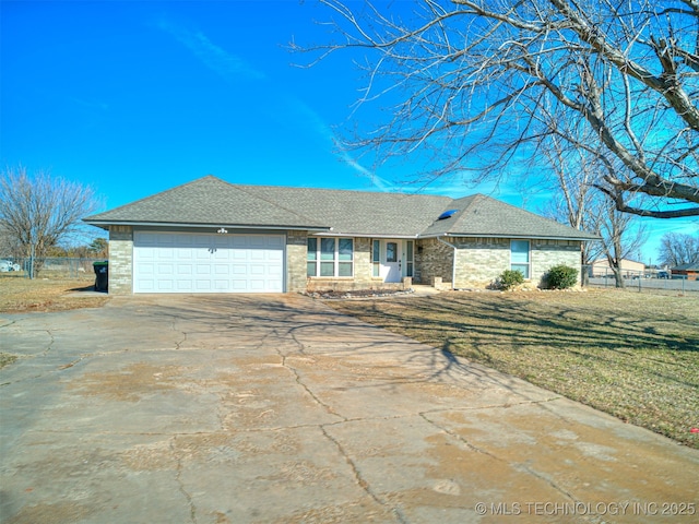 ranch-style home with fence, concrete driveway, a front yard, roof with shingles, and a garage