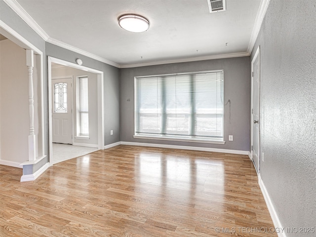 unfurnished room featuring visible vents, crown molding, and wood finished floors