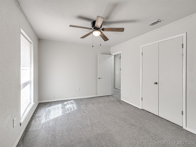 unfurnished bedroom with visible vents, baseboards, a ceiling fan, and carpet floors