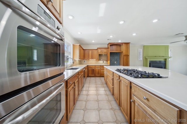 kitchen with backsplash, double oven, light countertops, gas cooktop, and a sink