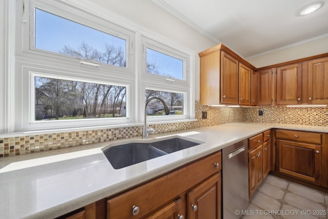 kitchen featuring a sink, stainless steel dishwasher, crown molding, and light countertops