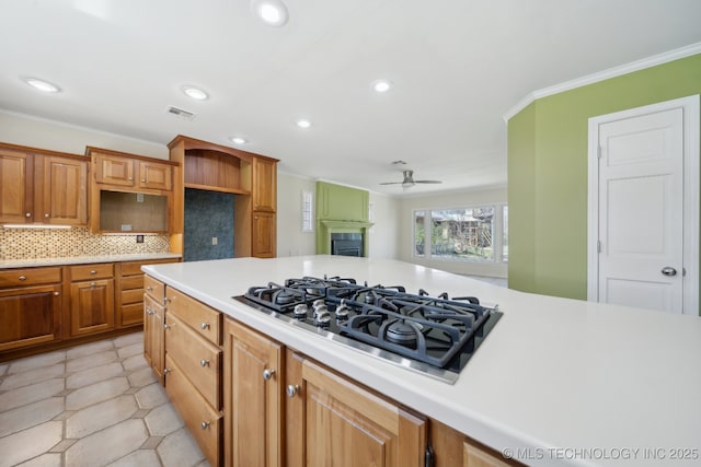 kitchen featuring visible vents, ceiling fan, ornamental molding, decorative backsplash, and black gas stovetop