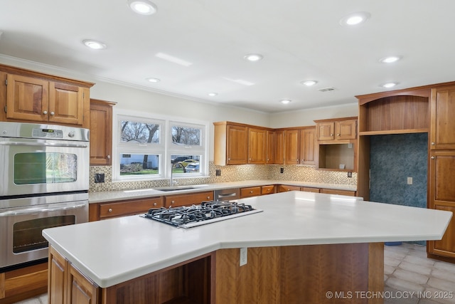 kitchen with gas cooktop, a kitchen island, a sink, decorative backsplash, and double oven