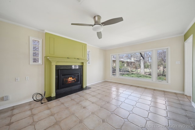 unfurnished living room featuring a glass covered fireplace, baseboards, ceiling fan, and ornamental molding