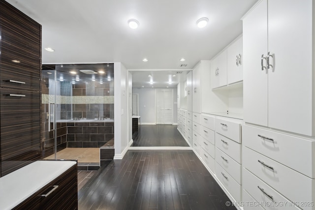 bathroom featuring baseboards, a tile shower, recessed lighting, wood finished floors, and vanity