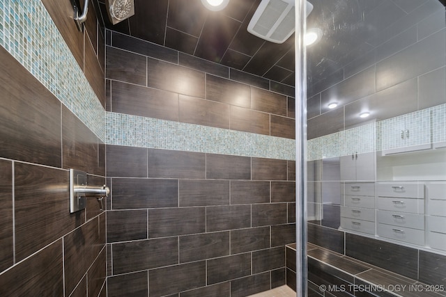 full bathroom featuring visible vents and tiled shower