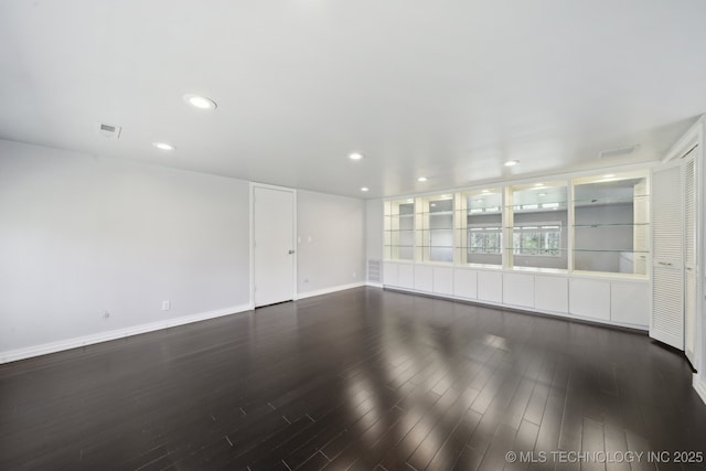 empty room with recessed lighting, visible vents, baseboards, and wood finished floors