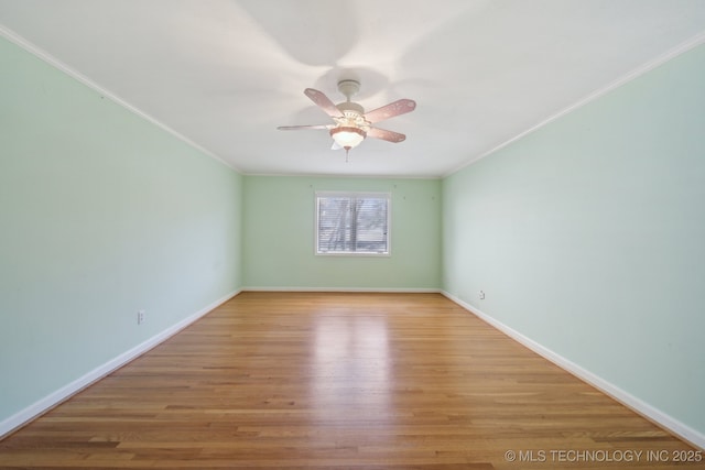unfurnished room featuring ceiling fan, wood finished floors, baseboards, and ornamental molding