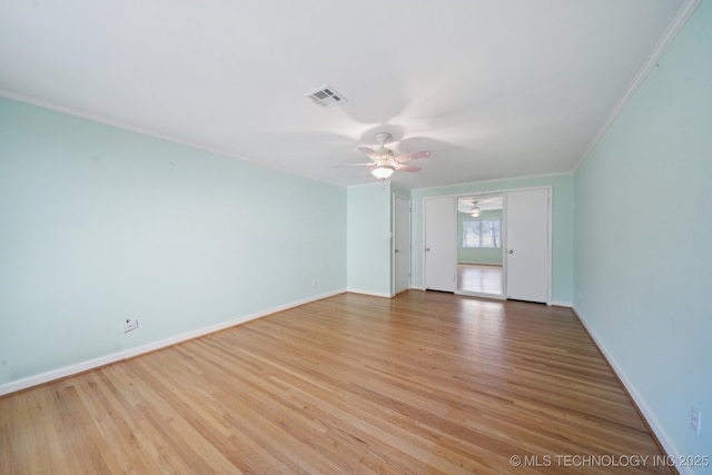 unfurnished room featuring visible vents, crown molding, light wood finished floors, baseboards, and ceiling fan
