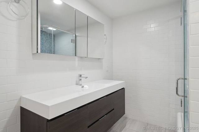 bathroom featuring vanity, tile walls, and a shower stall