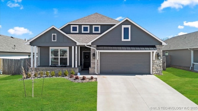 view of front facade featuring driveway, stone siding, fence, board and batten siding, and a front yard