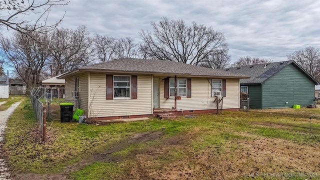 view of front of home with crawl space, fence, a front lawn, and a shingled roof