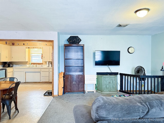 living area featuring visible vents and light carpet