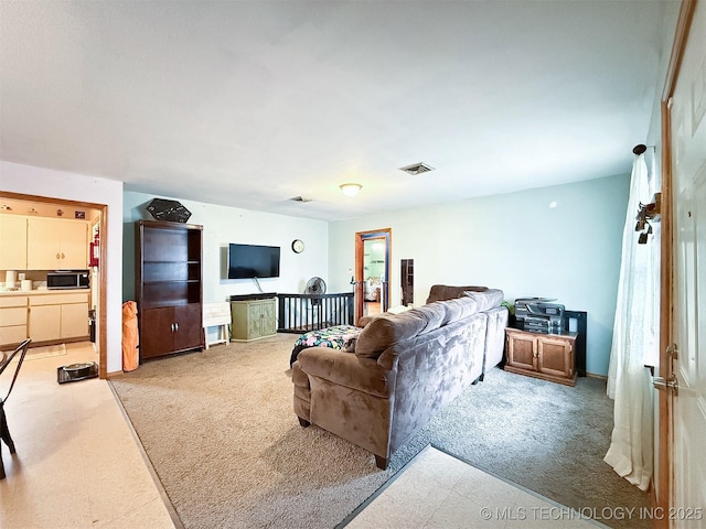 living area with visible vents and carpet