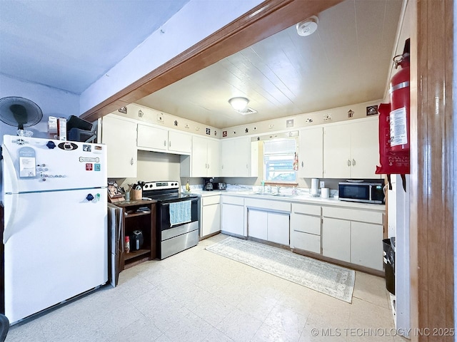 kitchen featuring light floors, light countertops, stainless steel appliances, white cabinetry, and a sink