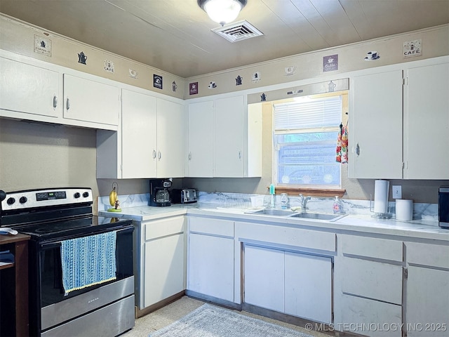 kitchen with visible vents, stainless steel electric stove, a sink, light countertops, and white cabinets