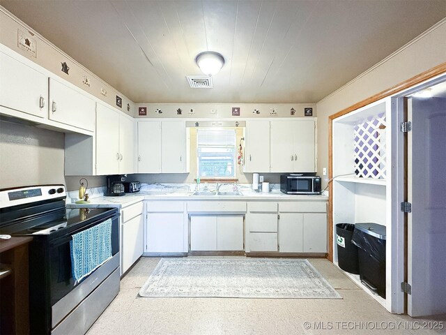 kitchen with visible vents, light countertops, stainless steel appliances, white cabinetry, and a sink