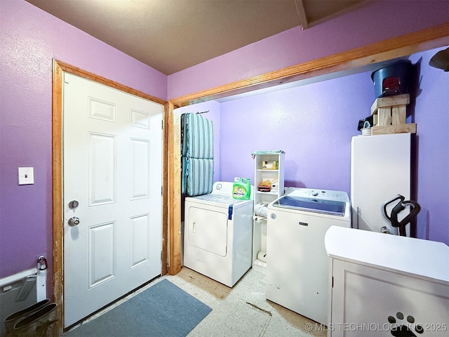 laundry room with laundry area, washing machine and dryer, and light floors