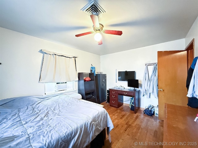 bedroom featuring visible vents, ceiling fan, and wood finished floors