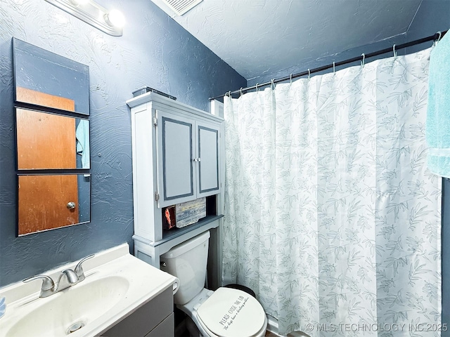 full bath with vanity, a shower with curtain, toilet, and a textured wall