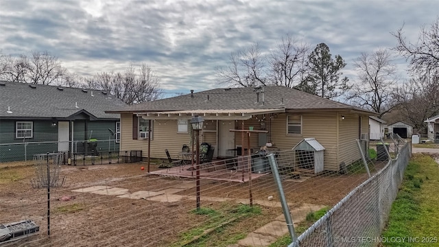 rear view of house with fence private yard, a patio, and roof with shingles