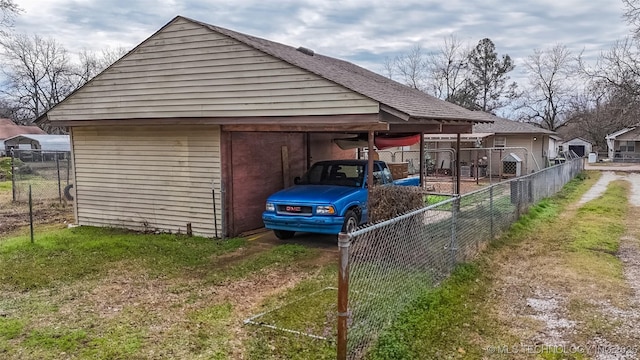 view of parking featuring a carport, driveway, and fence