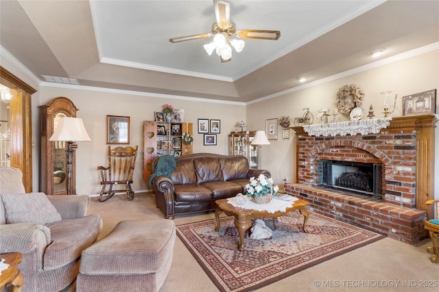 living room featuring visible vents, carpet floors, ornamental molding, ceiling fan, and a brick fireplace