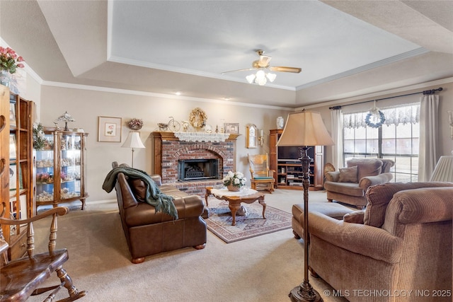 living area with a raised ceiling, carpet floors, ceiling fan, and crown molding