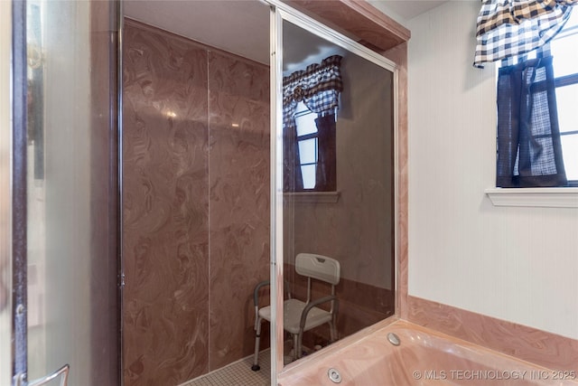 bathroom featuring a bath and a shower stall