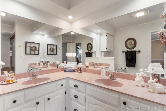 bathroom featuring a sink, double vanity, recessed lighting, and crown molding