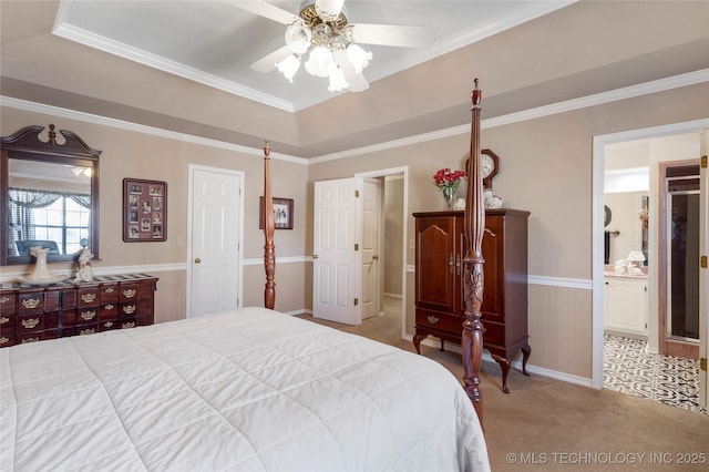 bedroom with ceiling fan, crown molding, a raised ceiling, carpet flooring, and connected bathroom