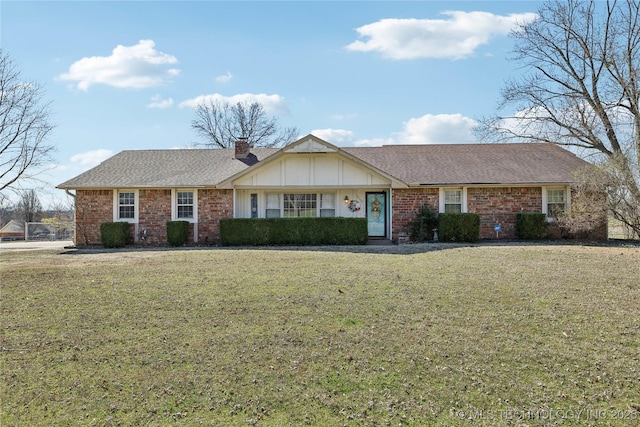 single story home with board and batten siding, a chimney, a front yard, and roof with shingles