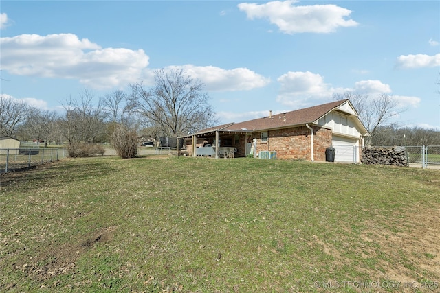 view of yard with an attached garage and fence