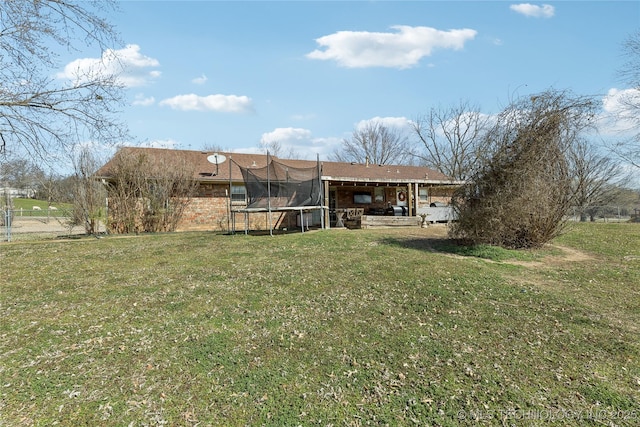 view of yard with a trampoline and fence