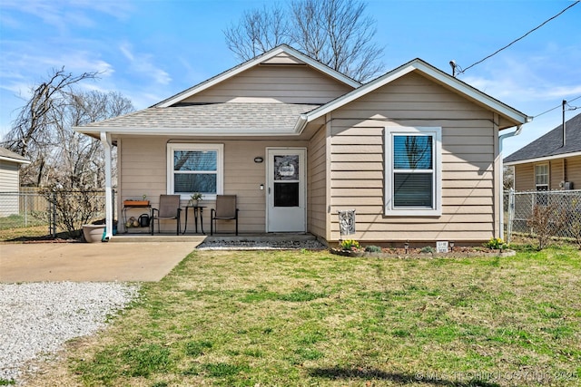 view of front of house featuring a patio, a shingled roof, a front lawn, and fence