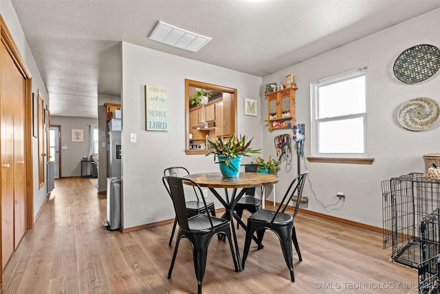 dining space with visible vents, baseboards, and light wood-style floors