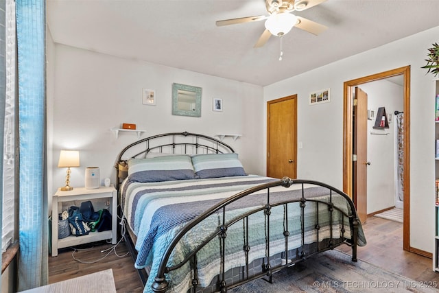 bedroom with ceiling fan, baseboards, and wood finished floors