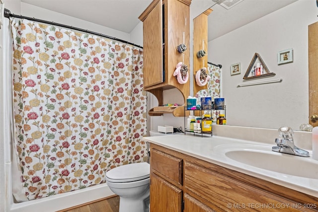 bathroom featuring vanity, a shower with shower curtain, wood finished floors, visible vents, and toilet