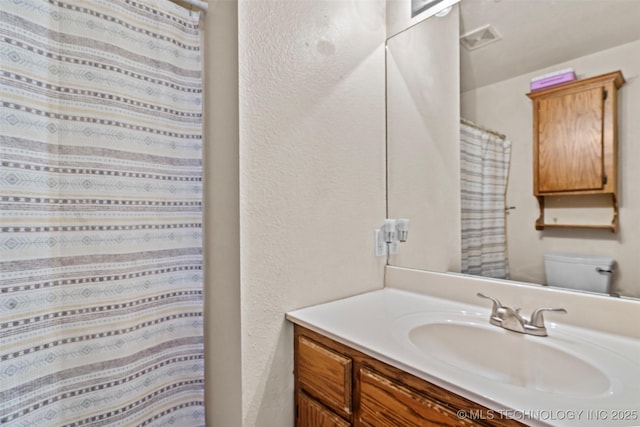 full bathroom featuring visible vents, toilet, vanity, and a shower with shower curtain