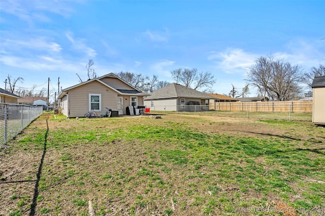 back of property featuring a fenced backyard and a lawn