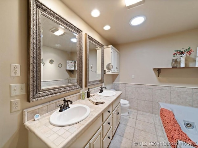 33861 S 4507th Rd, Afton, OK 74331 - full bathroom featuring tile patterned flooring, tile walls, double vanity, wainscoting, and a tub to relax in