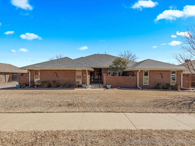 single story home with brick siding and a fenced front yard