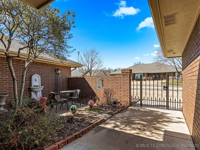 view of patio featuring a gate and fence