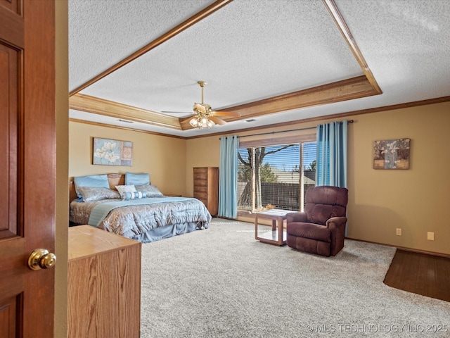 carpeted bedroom with crown molding, a textured ceiling, a raised ceiling, and baseboards