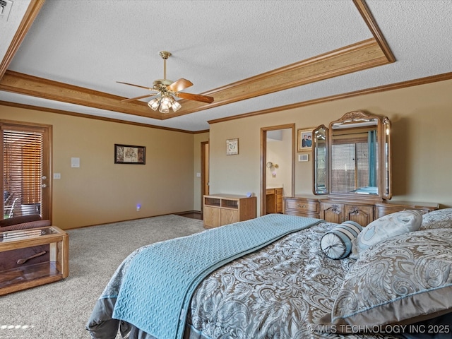 bedroom featuring ornamental molding, a ceiling fan, a tray ceiling, a textured ceiling, and carpet floors