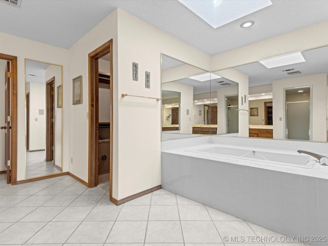 full bath with tile patterned flooring, visible vents, a shower stall, a garden tub, and a skylight